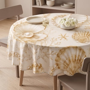 May include: A round tablecloth featuring a cream-colored background with a repeating pattern of golden-brown seashells, coral branches, and strings of pearls. The design includes large, detailed illustrations of open clams with pearls.