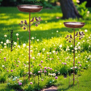 May include: Two bronze-colored bird feeders with a decorative tree branch design. Each feeder has a circular bowl, 9.5 inches in diameter, and stands 29.9 inches tall. The feeders are placed in a grassy garden setting.