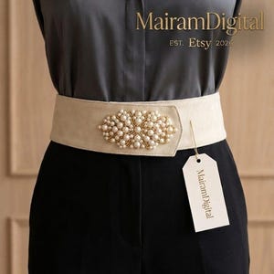 May include: A cream-colored belt with a gold and pearl embellishment. The belt is worn over a black outfit. The tag reads MairamDigital EST. Etsy 2026.