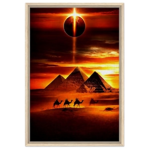 Op de afbeelding: Ingelijste kunstdruk met een Egyptische woestijnscène. De afbeelding toont piramides, kamelen en een hemelse gebeurtenis in een warm kleurenpalet van oranje, rood en geel. Het kunstwerk is geplaatst in een lichtgekleurde houten lijst.
