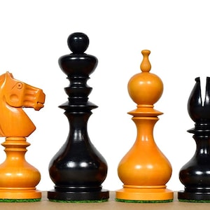 May include: A collection of six chess pieces, including a rook, knight, king, bishop, and pawn. The pieces are a mix of black and orange, with a glossy finish. The chess set is displayed on a light brown surface against a white background.
