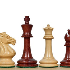 Pode incluir: Um conjunto de seis peças de xadrez de madeira dispostas em fila, apresentando uma torre castanho-avermelhada escura, um cavalo bege claro, um rei castanho-avermelhado escuro, uma rainha bege claro, um bispo castanho-avermelhado escuro e um peão bege claro, todos com bases de feltro verde.
