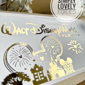 May include: Gold foil sticker featuring the text "Walt Disney World Florida" and a Mickey Mouse silhouette with images of fireworks, Cinderella's Castle, and the Spaceship Earth. The sticker has the text "Simply Lovely Foiled" above it.