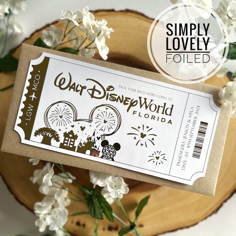 May include: A white ticket with gold foil lettering for a trip to Walt Disney World in Florida. The ticket says "Pack your bags, we're going to Walt Disney World Florida" and includes the dates "1st - 10th September 2024". The ticket is on a brown background with the words "Simply Lovely Foiled" in gold foil lettering.