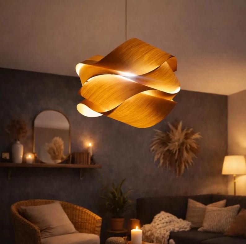 May include: A wooden pendant light fixture with a layered, wave-like design. The light fixture is made of warm-toned wood and hangs from a single cord. The light is on, illuminating the room with a soft glow. The fixture is a decorative element.