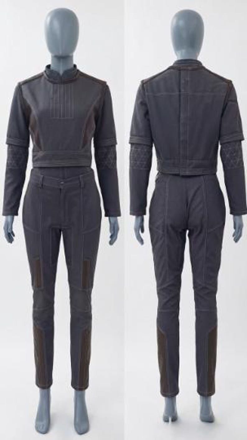 Puede incluir: Conjunto de dos piezas gris oscuro sobre maniqu&iacute;. La parte superior es una chaqueta corta con mangas largas y cuello mandar&iacute;n. Los pantalones son ajustados con detalles marrones. El conjunto est&aacute; hecho de un material resistente y tiene costuras visibles.