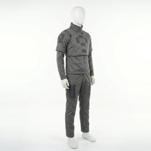 May include: A gray uniform displayed on a mannequin. The outfit includes a long-sleeved top with a high collar and a checkered pattern on the chest, along with matching pants. The uniform has several square patches.