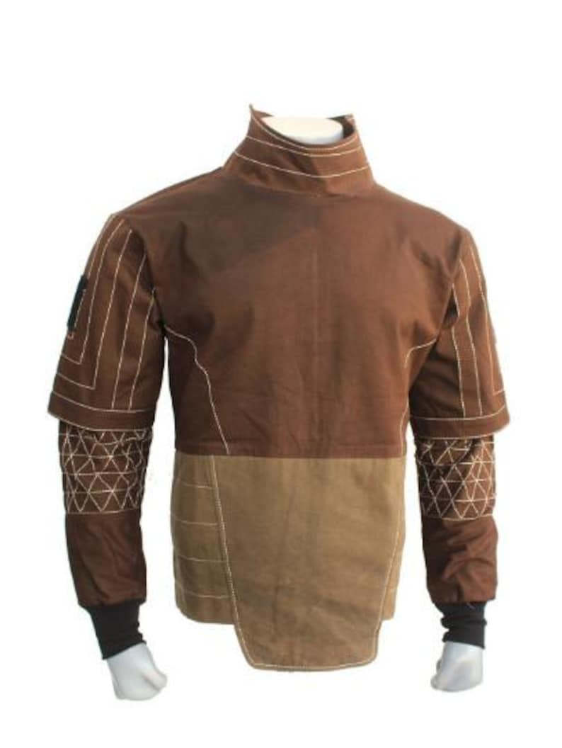 May include: A brown jacket with a high collar and contrasting tan lower section. White stitching details the seams and geometric patterns on the sleeves. The jacket has black cuffs and is displayed on a mannequin.