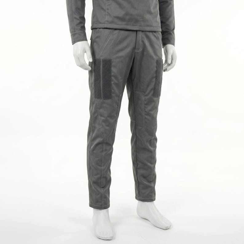 May include: Gray pants with two dark gray rectangular patches on the front of each leg. The pants have a matching gray top and are displayed on a mannequin. The pants have visible stitching.