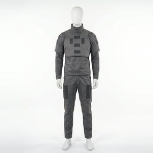 May include: A gray tactical uniform displayed on a mannequin. The outfit includes a high-neck jacket with a chest plate, long sleeves, and matching pants with knee pockets. The uniform is designed for protection and functionality.