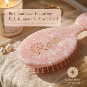 Op de afbeelding: Een lichtroze haarborstel met een gemarmerde textuur en de naam Rossi gegraveerd in goudkleurig schrift. De tekst Premium Laser Engraving – Fade-Resistant & Personalized is zichtbaar, evenals Custom Name • Eternal Shine.