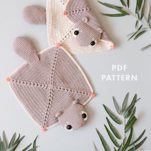 Peut inclure: Deux doudous au crochet avec une base carrée texturée, une petite tête aux yeux noirs et une queue. Une couverture est marron clair, l'autre est crème avec une tête marron clair. Le texte indique PDF PATTERN.