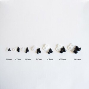 May include: Assortment of black plastic safety eyes for crafts, ranging in size from 4mm to 14mm. Each eye is paired with a white plastic washer.