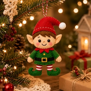 May include: A felt Christmas elf ornament featuring a red hat with a white pom-pom, a green tunic with a black belt and yellow buckle, and red and white striped leggings. The elf has pointed ears, rosy cheeks, and a smiling expression.
