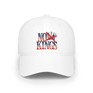 Könnte beinhalten: Weiße Baseballkappe mit dem Text "NO KINGS" in Rot, Weiß und Blau, mit einem roten X über einer Krone. Die Kappe hat einen gebogenen Schirm.
