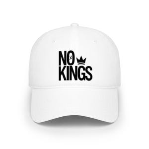 Könnte beinhalten: Weisse Baseballkappe mit dem Text "NO KINGS" in fetten schwarzen Buchstaben. Das Design beinhaltet eine Kronengrafik über dem Wort "KINGS". Die Kappe hat einen gebogenen Schirm und eine strukturierte Passform.