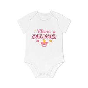 Può includere: Body da neonato bianco con la scritta rosa "Kleine Schwester", decorato con cuori, stelle e un ciuccio. Il body ha maniche corte e chiusure a scatto.