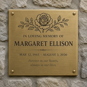 May include: A rectangular brushed brass memorial plaque featuring an engraved rose illustration at the top. The text reads: IN LOVING MEMORY OF MARGARET ELLISON, MAY 12, 1945 &ndash; AUGUST 3, 2020, Forever in our hearts, always in our lives.