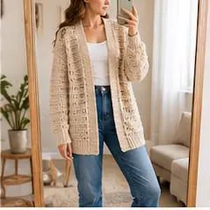 May include: A beige, open-front cardigan with a textured knit design. The long-sleeved sweater is worn over a white top and blue jeans. The cardigan has a relaxed fit and is knee-length.