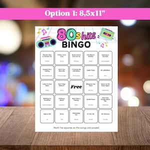 May include: A white 80s Hits Bingo game card with a pink and teal design. The card features song titles in boxes, a boombox graphic, and the text "Option 1: 8.5x11". The card is on a wooden surface.