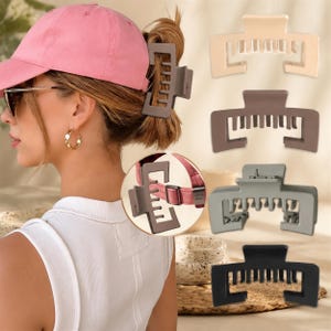 May include: A set of four rectangular hair claw clips in matte beige, brown, gray, and black. Each clip features a wide, open-frame design with multiple interlocking teeth for securing hair. One brown clip is shown in use and in a circular inset.