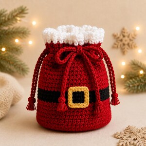 May include: A red crochet drawstring pouch featuring a white textured trim at the top, a black horizontal band across the center, and a yellow square buckle detail. The bag includes two long red braided cords with tassels for closure and carrying.