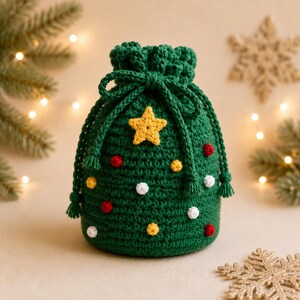 May include: A dark green crocheted drawstring pouch shaped like a Christmas tree, featuring a yellow crocheted star at the top and small red, yellow, and white crocheted spheres scattered across the surface to resemble festive ornaments.