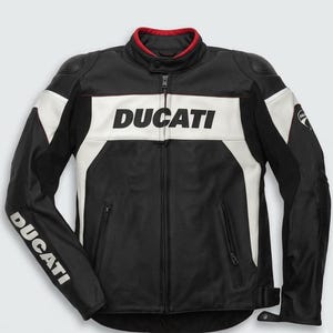 Puede incluir: Chaqueta de moto negra y blanca con la palabra "DUCATI" en el pecho. La chaqueta tiene un cuello rojo y detalles blancos en los hombros y las mangas. El logotipo de Ducati está en la manga.