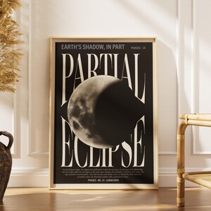 May include: A rectangular wall art print featuring a black background with a large, centered image of a partial lunar eclipse. The text reads "EARTH'S SHADOW, IN PART", "PARTIAL ECLIPSE", "PHASES - 14", and "PHASES - NO. 14 - LUNAR DATA" in white serif font.