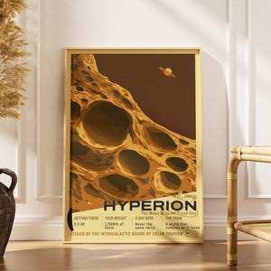 May include: A rectangular poster in a light wood frame featuring a brown and yellow illustration of the moon Hyperion with deep craters. The text reads HYPERION, The Moon With No Fixed Day, and includes data on weight, distance, and solar tourism.