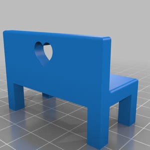 Könnte beinhalten: Ein kleiner, leuchtend blauer Hocker mit einem herzförmigen Ausschnitt in der Rückenlehne. Die Miniatur-Bank hat vier Beine und eine Sitzfläche, ideal für dekorative Zwecke oder Puppenhäuser.