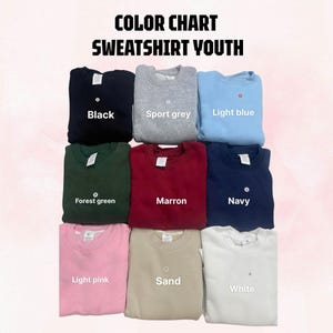 May include: A color chart for youth sweatshirts featuring nine crewneck pullovers in black, sport grey, light blue, forest green, maroon, navy, light pink, sand, and white. The text reads COLOR CHART SWEATSHIRT YOUTH with labels for each color.