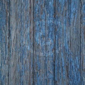 Puede incluir: Primer plano de una superficie de madera desgastada pintada de azul. La pintura se está descascarando y agrietando, revelando la veta natural de la madera debajo.