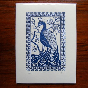 May include: Blue and white print of a peacock with a decorative border. The print is numbered 1/50 and signed "R.W."