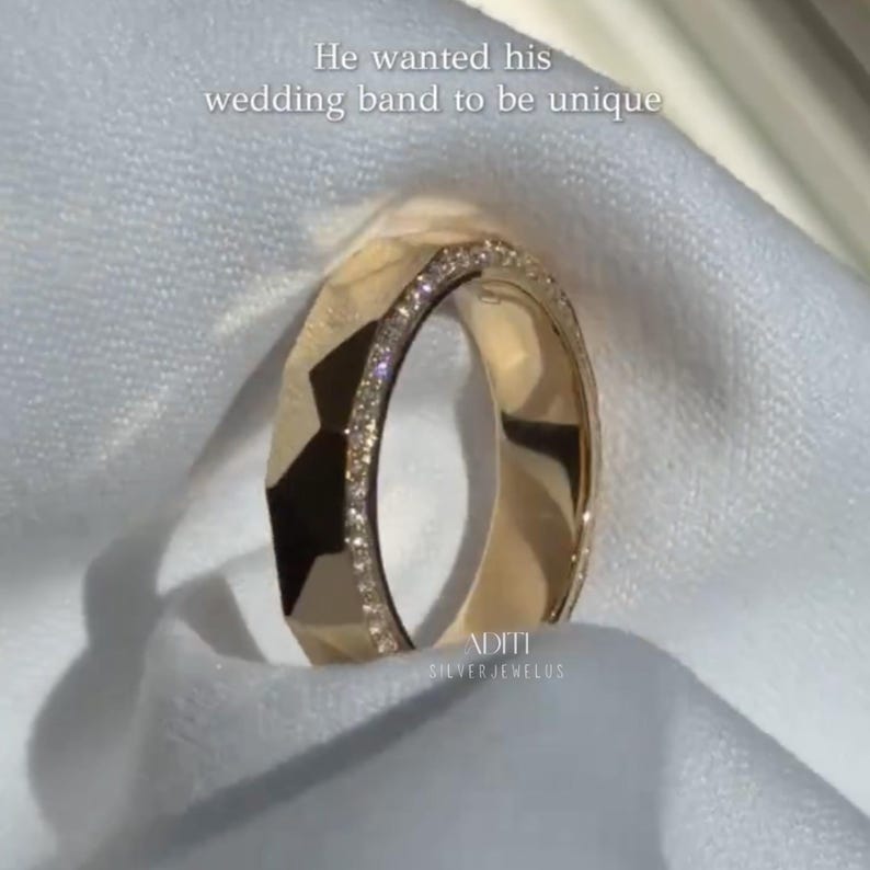 May include: Modern faceted men's wedding band crafted in solid 14K yellow gold featuring a geometric exterior and pavé-set lab diamonds along one side of the band. The text "BY ADITISILVERJEWELUS" is visible at the bottom.