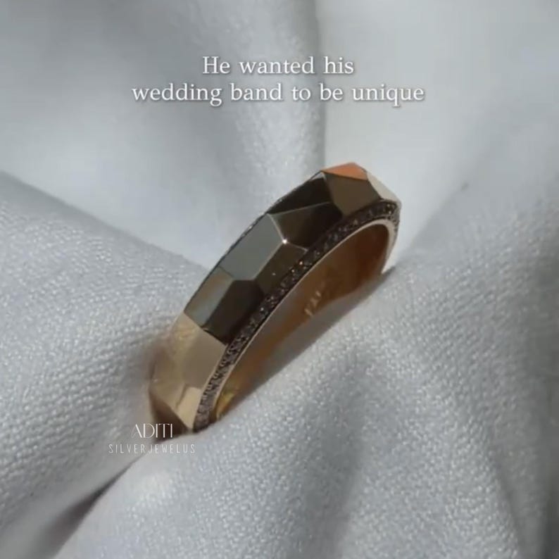 May include: Modern faceted men's wedding band crafted in solid 14K yellow gold featuring a geometric exterior and pavé-set lab diamonds along one side of the band. The text "BY ADITISILVERJEWELUS" is visible at the bottom.