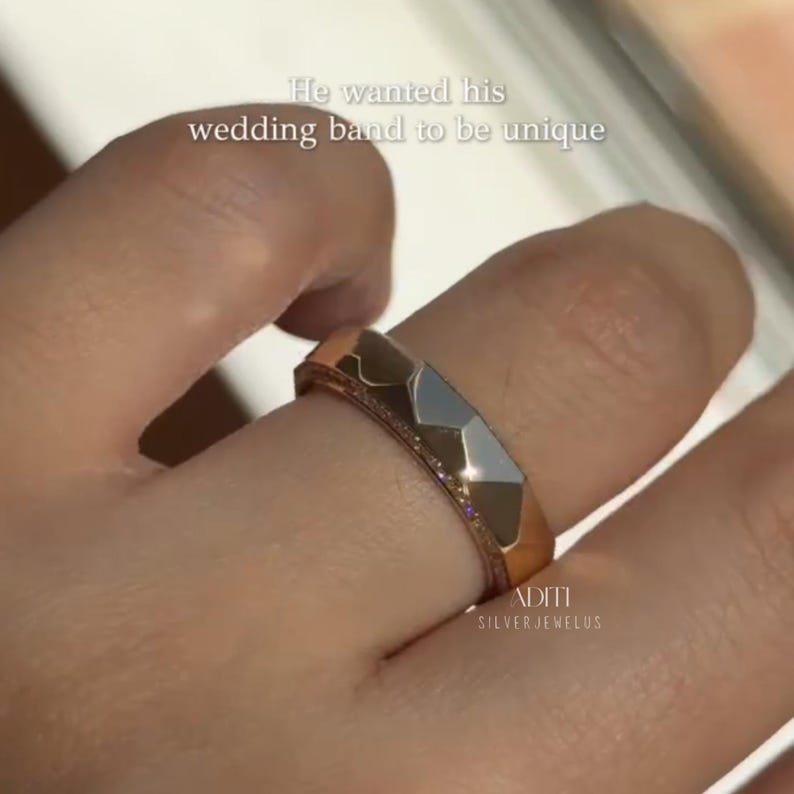 May include: Modern faceted men's wedding band crafted in solid 14K yellow gold featuring a geometric exterior and pavé-set lab diamonds along one side of the band. The text "BY ADITISILVERJEWELUS" is visible at the bottom.