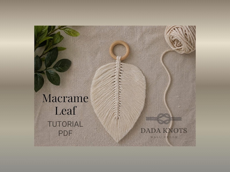 May include: A cream macrame leaf wall hanging with a wooden ring and central vein design. The image includes a ball of yarn and the text "Macrame Leaf TUTORIAL PDF" and "DADA KNOTS WALL DECOR".