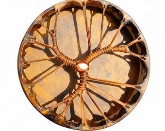 May include: A circular frame drum with a tan, stretched skin head. The back features a brown leather lacing system arranged in a branching, tree-like pattern that converges at the center, where a small, smooth, white stone is secured.