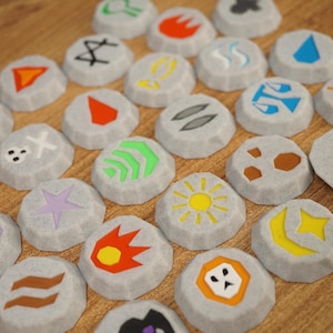 May include: A collection of circular, light grey speckled tokens, each featuring a unique, brightly coloured graphic symbol. The symbols include various shapes like stars, suns, flames, and abstract icons in colours such as red, yellow, green, and blue.
