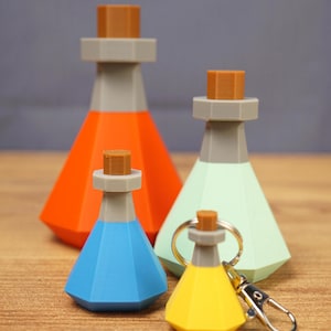 May include: A collection of four geometric potion bottle figures in orange, mint green, blue, and yellow. Each bottle features a gray neck, a brown hexagonal stopper, and a faceted body. The smallest yellow bottle includes a silver metal keychain.