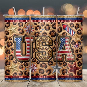Puede incluir: Un vaso cilíndrico con tapa y pajita que presenta un fondo con estampado de leopardo. El diseño incluye las letras USA en una fuente universitaria con patrones de bandera estadounidense, estrellas doradas, fuegos artificiales y bordes de lentejuelas.