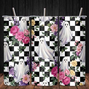 May include: A cylindrical tumbler with a straw featuring a repeating pattern of white ghosts, pink and yellow flowers, green leaves, and a black and white checkered background. The design wraps around the entire surface of the tall beverage container.