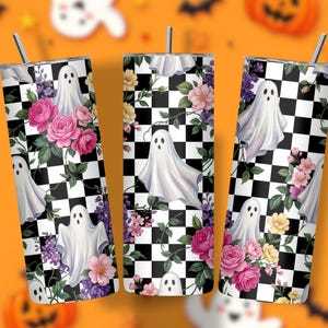 May include: Three cylindrical tumblers with metal straws, featuring a black and white checkered pattern overlaid with white ghost illustrations and clusters of pink, purple, and yellow flowers with green leaves on a white background.