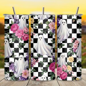 May include: A cylindrical stainless steel tumbler with a straw, featuring a repeating pattern of white ghosts, pink and yellow roses, and purple flowers set against a black and white checkered background. The design wraps around the entire vessel.