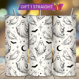 May include: A cylindrical stainless steel tumbler featuring a white background with a repeating black line art pattern of ghosts, bats, crescent moons, and stars. The tumbler includes a metal straw and a banner at the top reading GIFT 1 STRAIGHT.