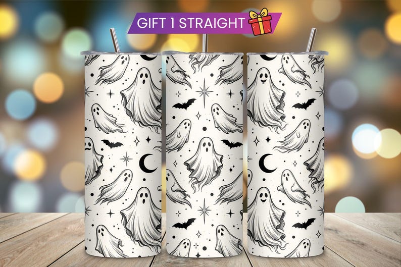 May include: A cylindrical stainless steel tumbler featuring a white background with a repeating black line art pattern of ghosts, bats, crescent moons, and stars. The tumbler includes a metal straw and a banner at the top reading GIFT 1 STRAIGHT.