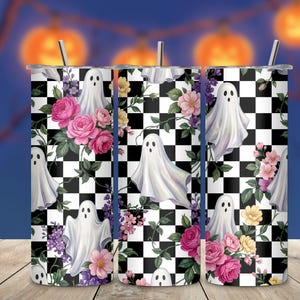 May include: A cylindrical tumbler with a metal straw featuring a black and white checkered pattern overlaid with white ghost illustrations, pink roses, and small purple and yellow flowers. The design covers the entire surface of the drinkware.
