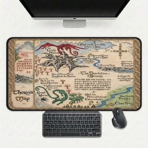 May include: A rectangular desk mat featuring a map with text and illustrations. The map depicts mountains, a dragon, and a river. The text includes "Chorin's Map" and "The Desolation of Smaug". A keyboard and mouse are below the mat.