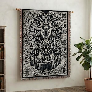 May include: A rectangular woven wall tapestry featuring a black and white graphic design of a horned goat head with wings, a central pentagram, and various occult symbols. The scene includes hooded figures around a table with candles.